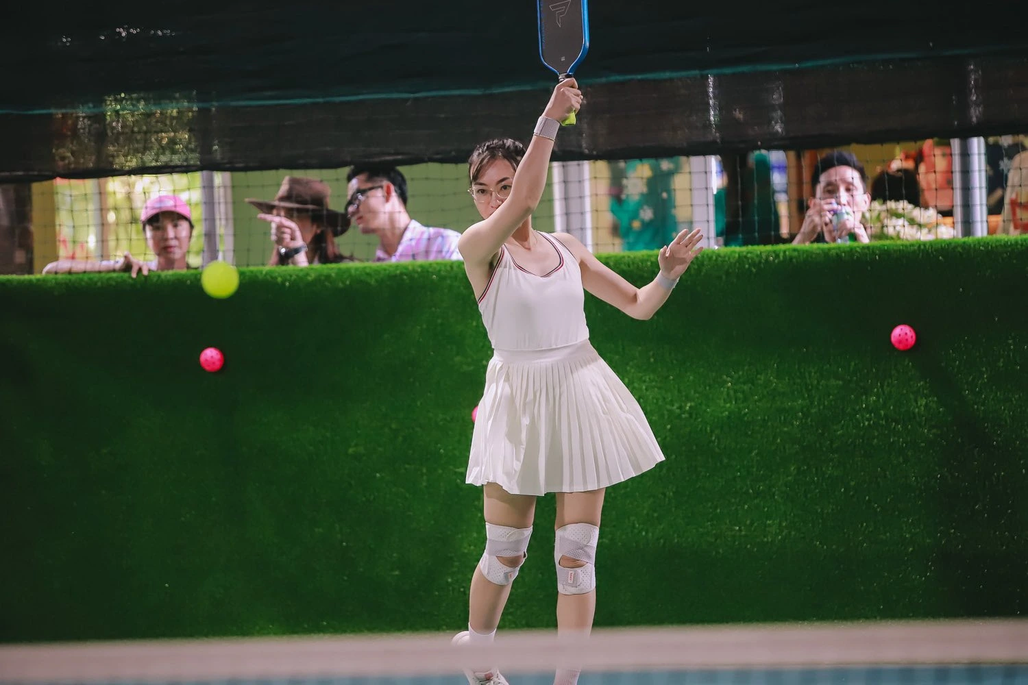 Female pickleball player mid forehand swing at Courtyard Pickle courts, Da Nang