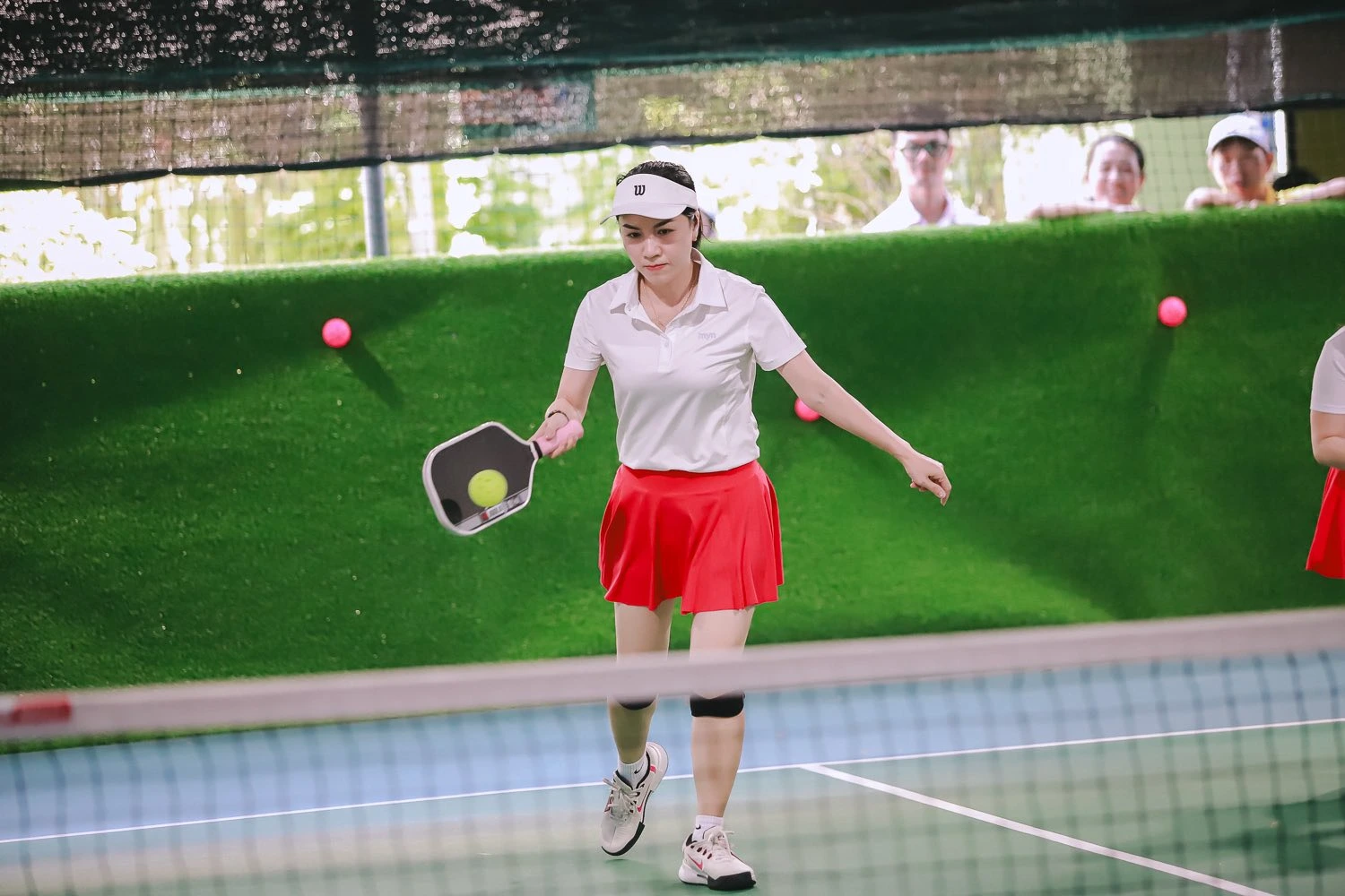 Female pickleball player preparing to hit at Courtyard Pickle, Da Nang