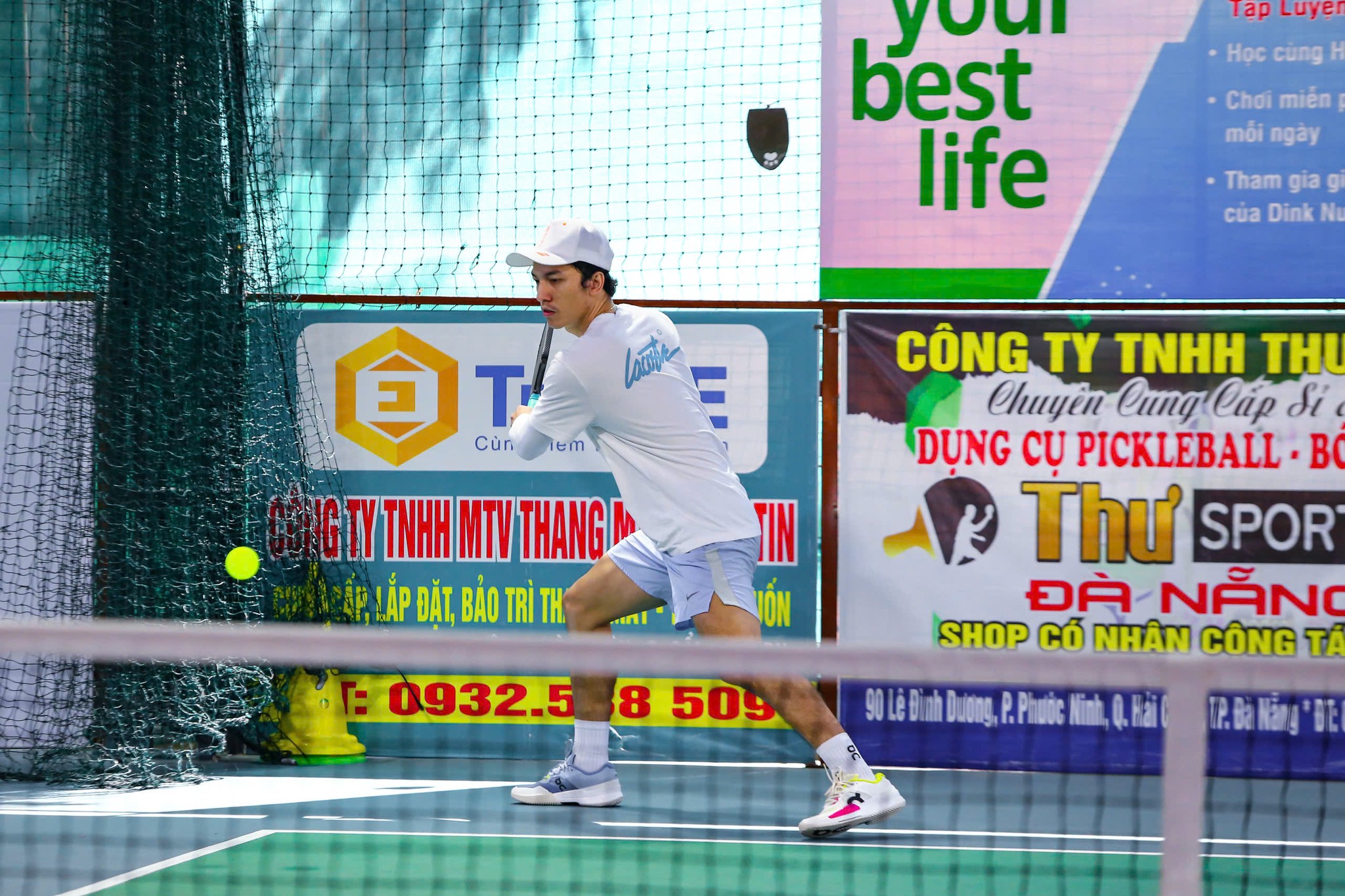 Pickleball player executing a backhand shot at Courtyard Pickle courts, Da Nang
